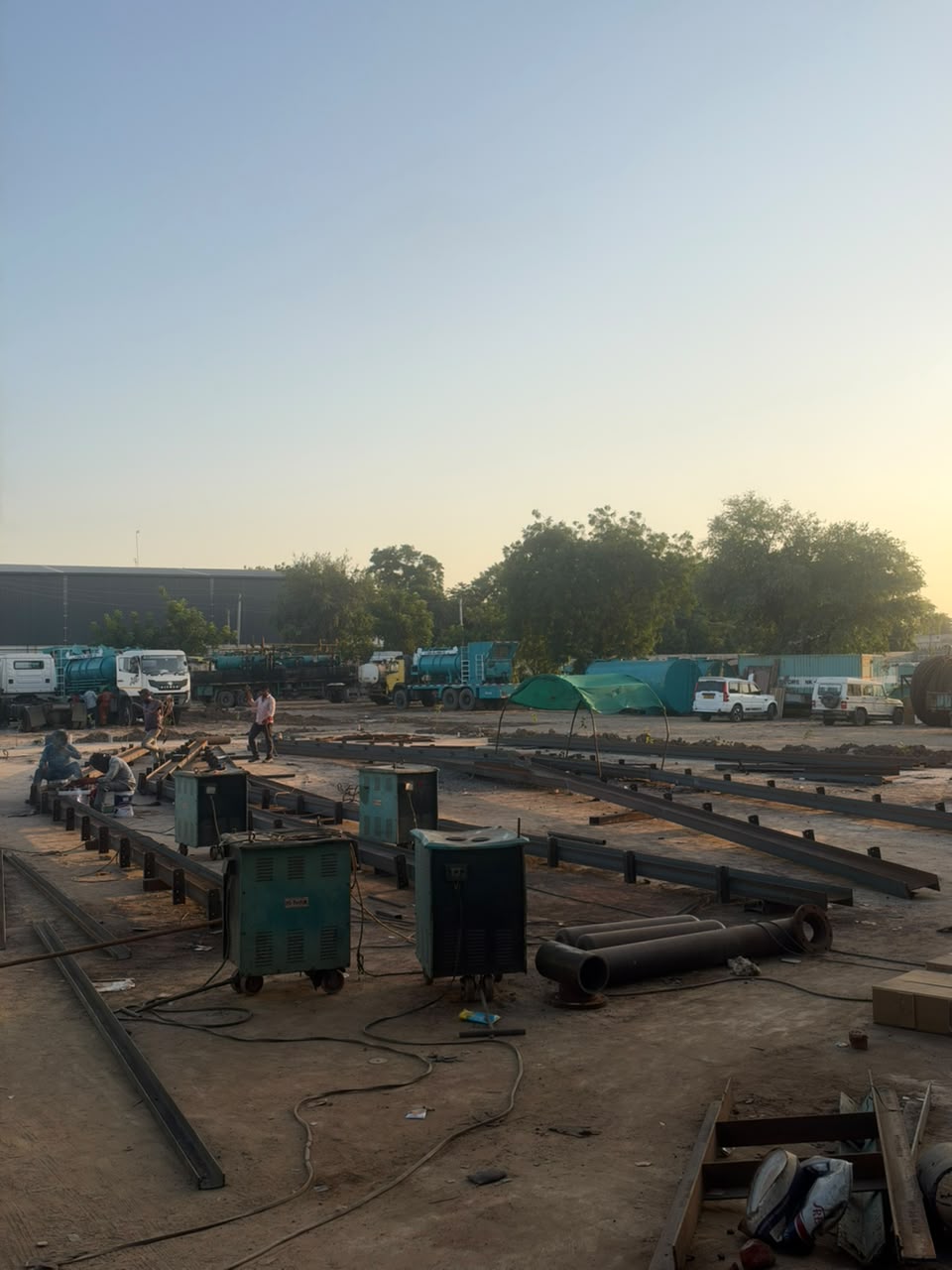 Heavy welding machinery, piping spools, and structural steel assembly in Mahesana yard